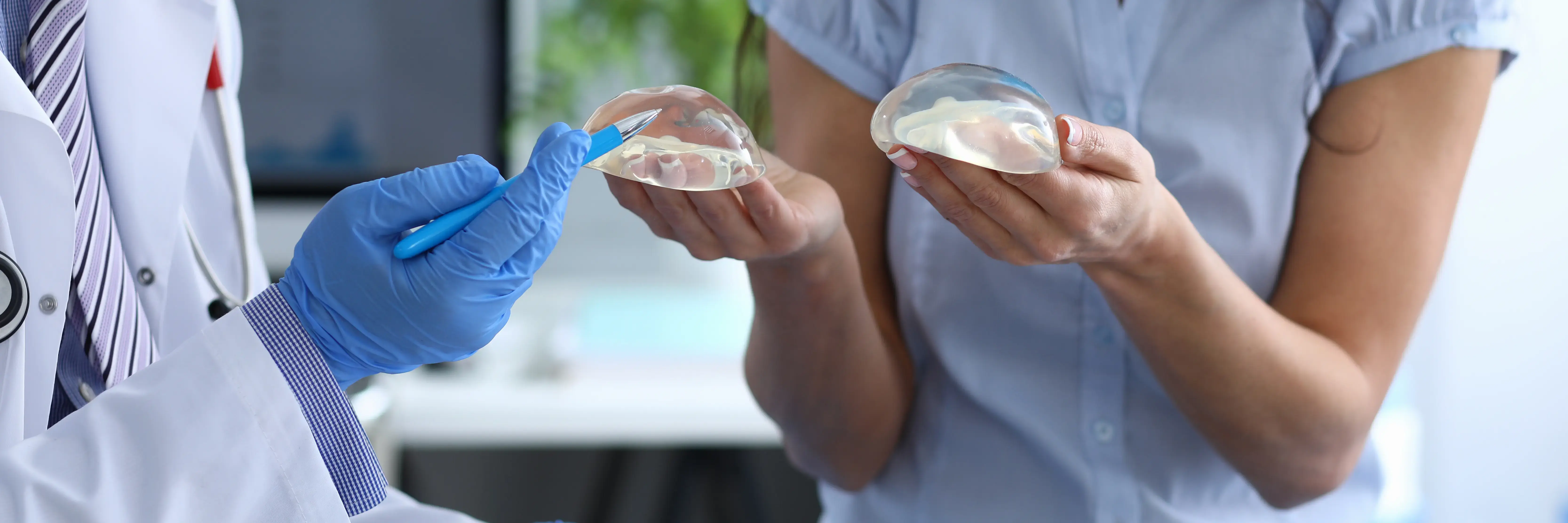 Plastic surgeon explaining different types of breast implants to a patient