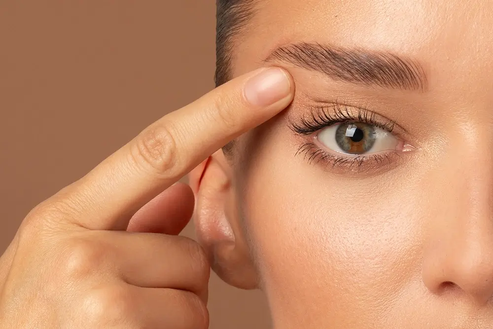 Close-up of a woman lifting her eyelids